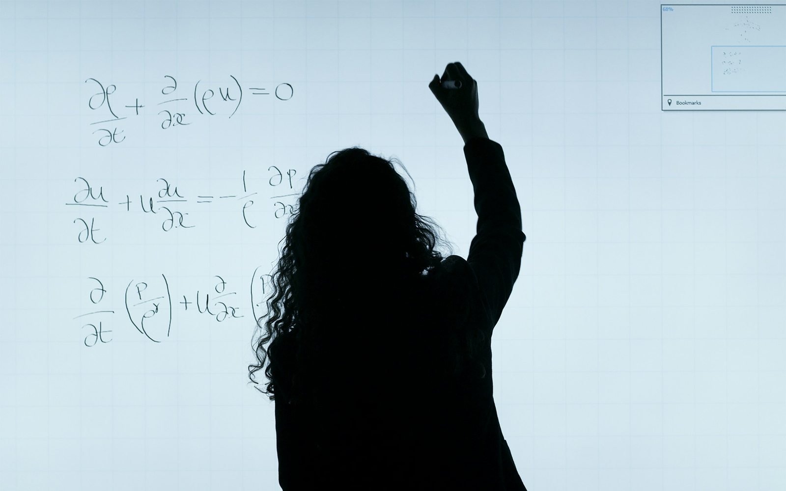 A student writing advanced mathematical equations on a whiteboard