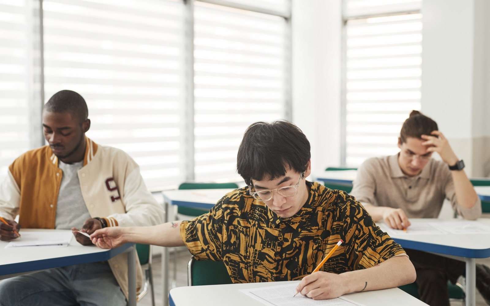 Students sitting a mock exam at spaced desks in a bright exam room