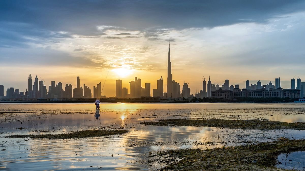 Dubai skyline and Burj Khalifa reflected in the water at sunrise